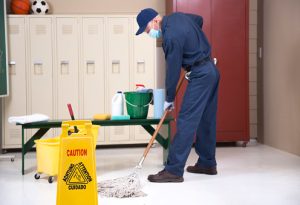 Senior adult Janitor keeps the floors cleaned and sanitized due to the virus